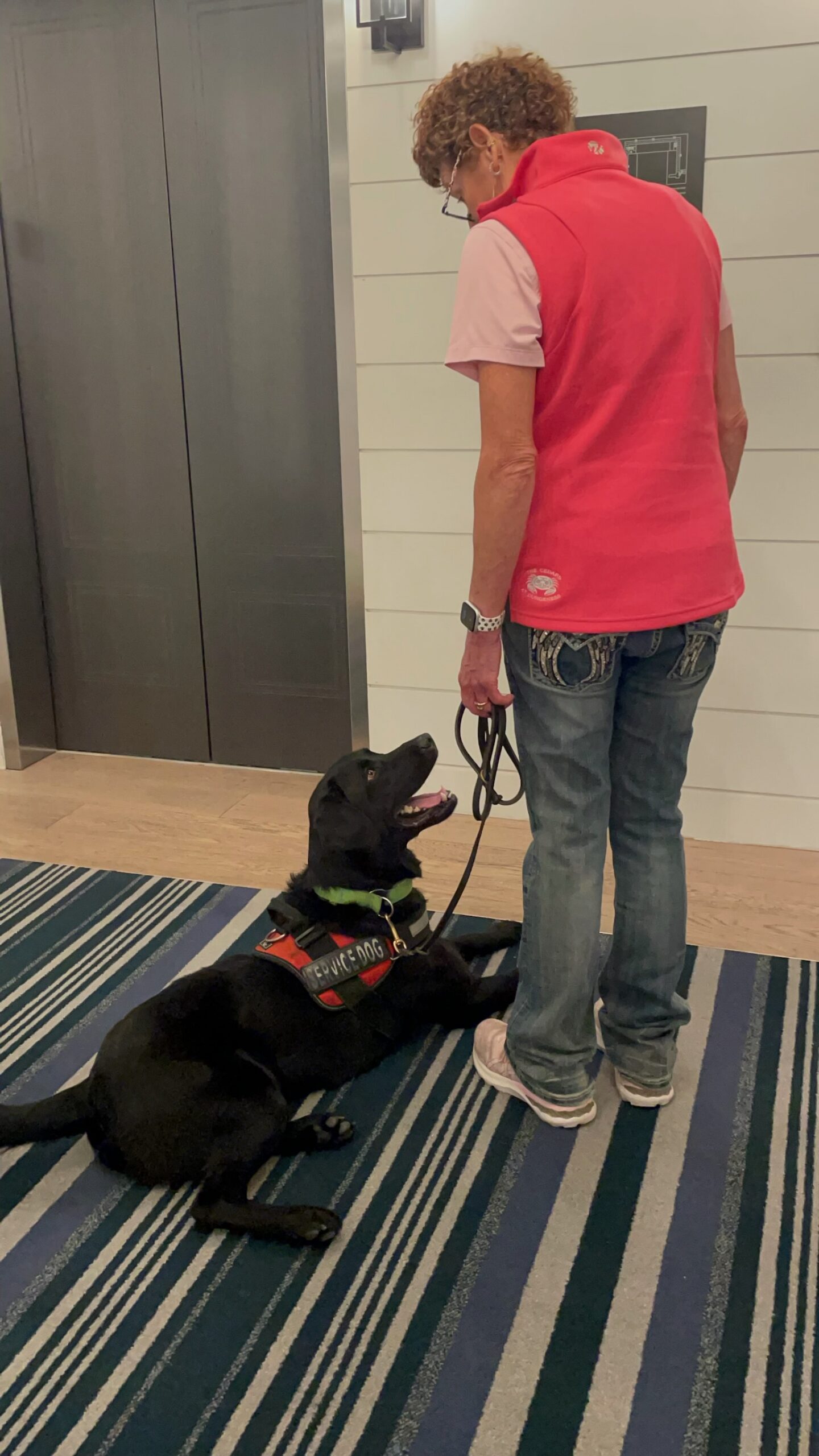 Woman and her service dog waiting for an elevator